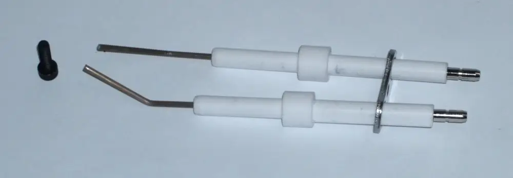 Zündelektrodensatz von Daikin, bestehend aus zwei elektrodenähnlichen Teilen mit isolierenden Hüllen und einem kleinen schwarzen Zubehörteil, auf hellem Hintergrund.